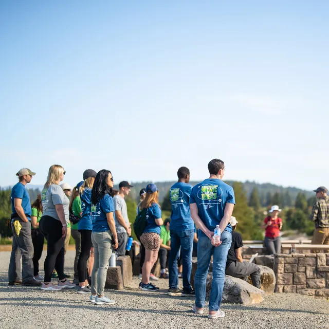 diverse group of Arbor Day Foundation team members listening to planting partner.