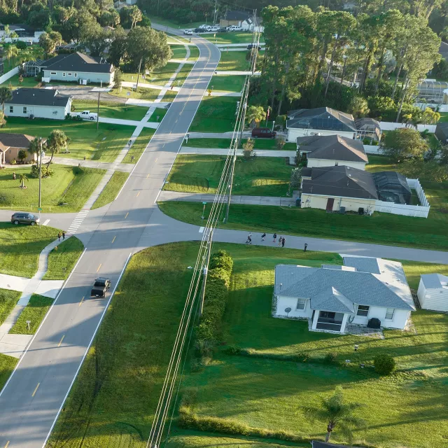 drone view of neighborhood homes with lack of trees and visible power lines.