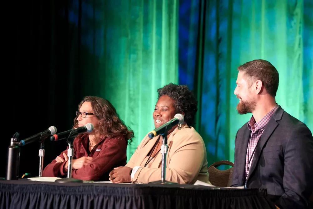 speakers at a table at a conference