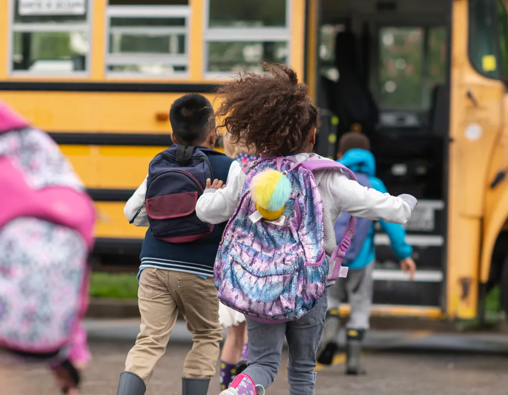 elementary school students running to the bus.