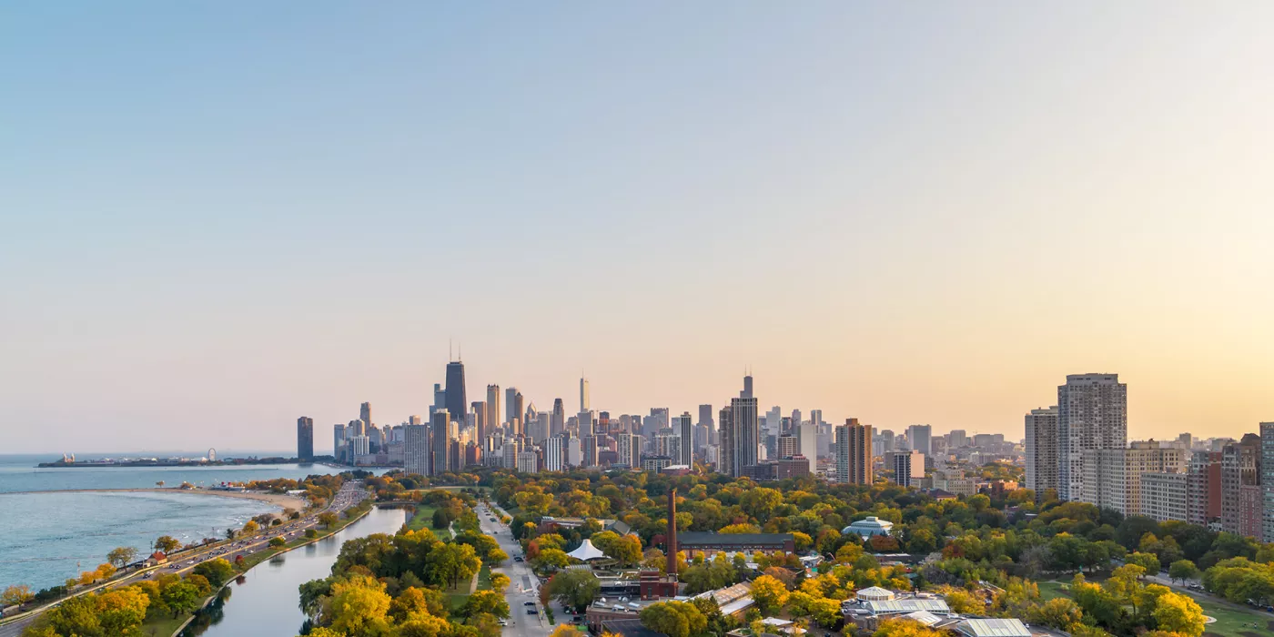 Aerial view of Chicago's skyline with vibrant autumn colors and Lake Michigan shimmering below.