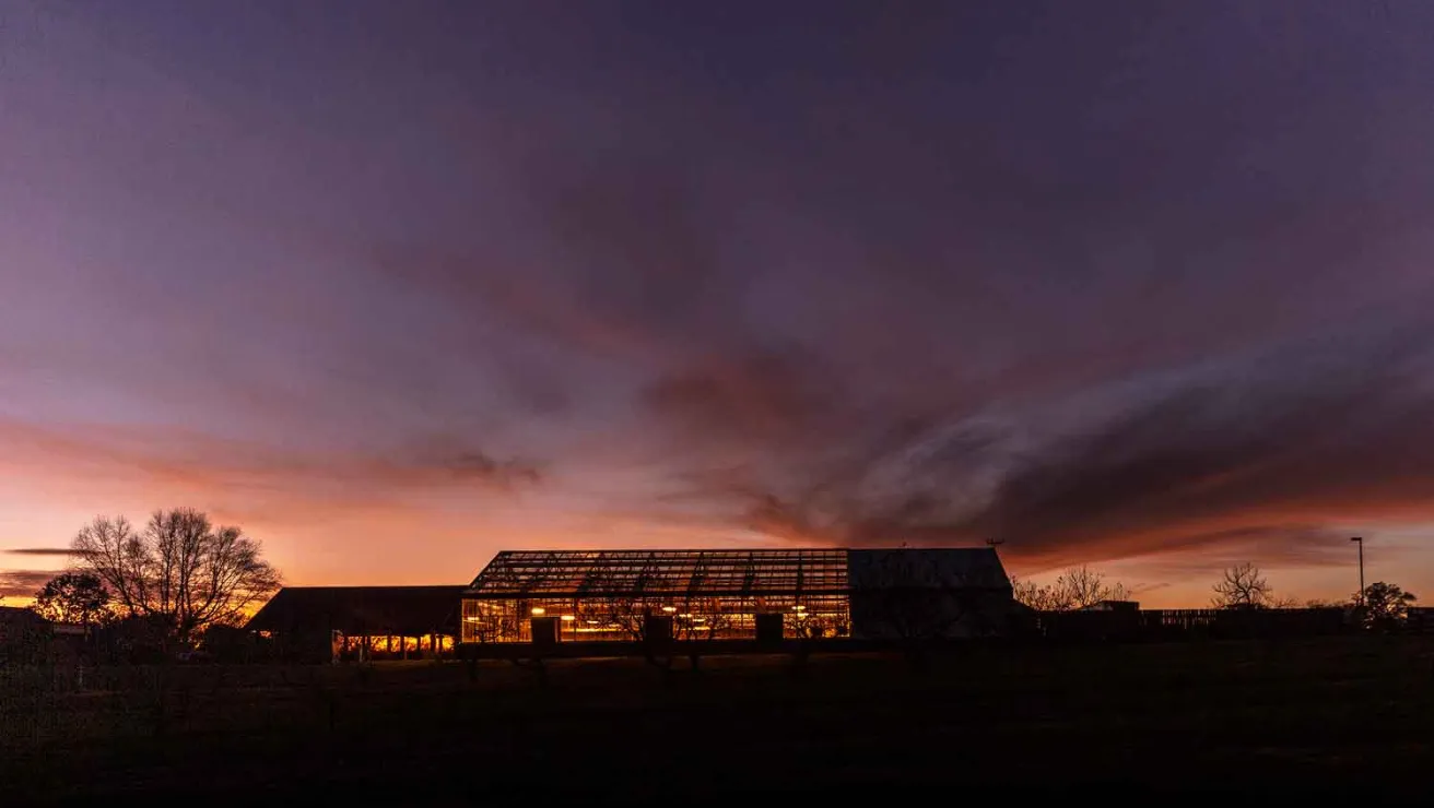 A picturesque building at sunset, featuring a large glass roof.