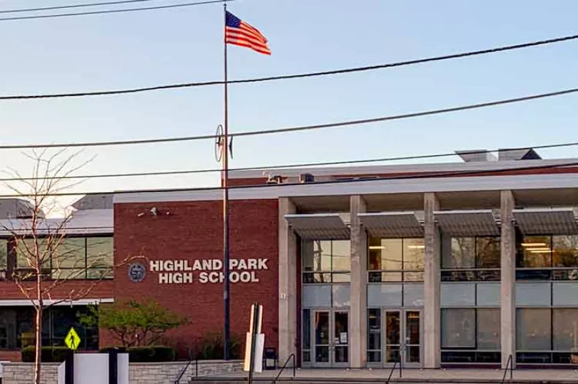 Highland Park High School building's front view with a flag waving.