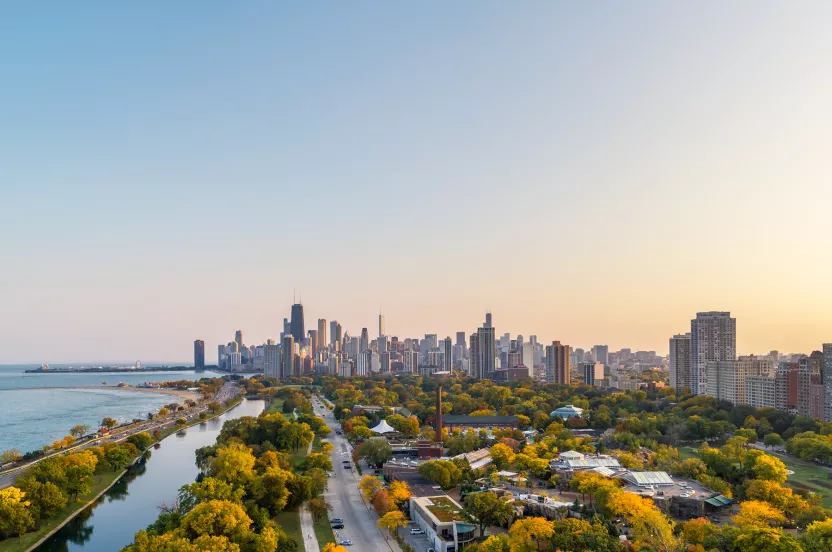 Aerial view of Chicago's skyline with vibrant autumn colors and Lake Michigan shimmering below.