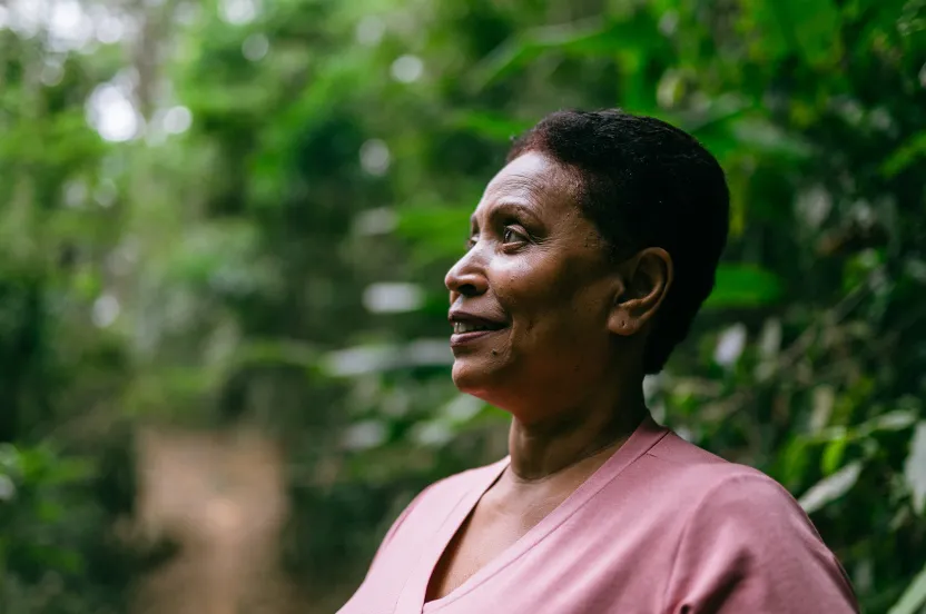 woman smiling and looking out at trees.