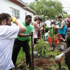 Several people gathered to plant trees in a backyard.