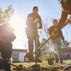 Group of people with shovels planting a tree in the fall.