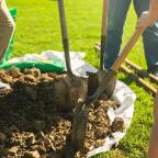 Three people with shovels in dirt